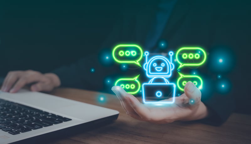 Persona sosteniendo un holograma brillante de un chatbot con iconos de burbujas de diálogo flotantes.